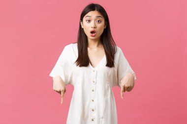 Güzellik, insanların duyguları, yaz tatili ve tatil konsepti. Şaşırmış ve meraklı Asyalı bayan müşteri mağazadaki teklif hakkında soru soruyor, ağzını aç ve parmaklarını aşağı doğru uzat.