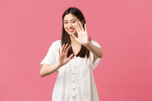 Schoonheid, mensen emoties en zomer vrijetijdsbesteding en vakantie concept. speels glimlachen gelukkig koreaans meisje, lachen en blozen als vragen stop schieten me, roze achtergrond — Stockfoto