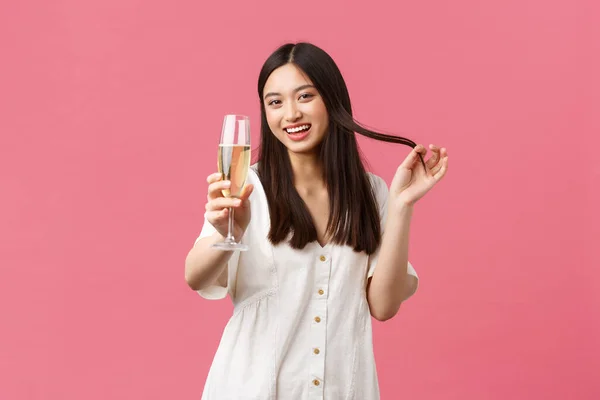 Kutlama, parti tatili ve eğlence konsepti. Cilveli ve cilveli genç bir kadın cam şampanyayla erkeği kutlama etkinliğinde baştan çıkarmaya çalışıyor, gülüyor ve gülümsüyor. Şerefe diyor. — Stok fotoğraf
