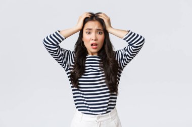 Yaşam tarzı, insanların duyguları ve gelişigüzel kavramlar. Sorunlu genç kadın paniğe kapıldı, korkunç bir şey olduğu için kendini kötü hissetti, kafasını tuttu ve kameraya baktı endişeli, beyaz arka plan