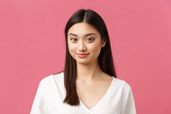 Salon de beauté, soins capillaires et produits de soins de la peau concept de publicité. Gros plan de jeune jolie femme asiatique souriant caméra timide, debout fond rose romantique — Photo