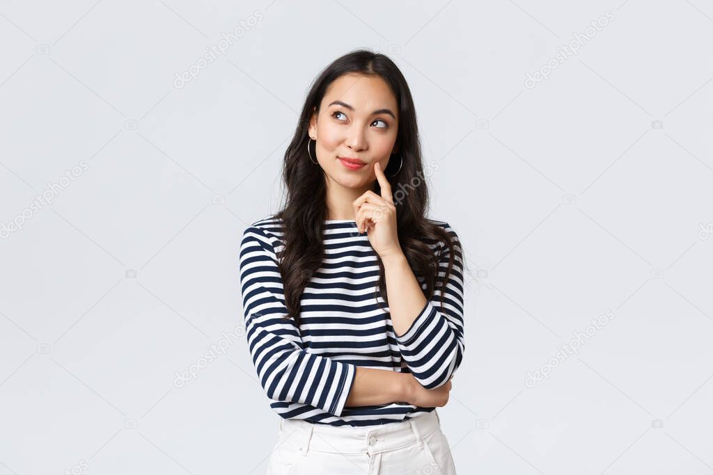 Lifestyle, people emotions and casual concept. Thoughtful stylish young woman smiling pleased, dreaming or imaging perfect plan, have interesting idea, thinking and looking upper left corner