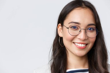 İş, finans ve istihdam, başarılı kadın girişimciler konsepti. Gülümseyen Asyalı iş kadınının yüzü, ofiste çalışıyor, gözlük takıyor ve kendinden emin bir şekilde kameraya bakıyor.