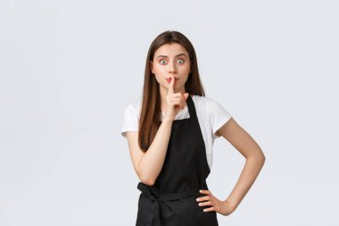 Küçük işletmeler, çalışanlar ve kahve dükkanı konsepti. Ciddi bir garsondan memnun değilim, sessiz ol. Kararlı bayan barista sessiz olmasını ve sır tutmasını söyler. Satıcı kadın üniforma giyiyor.