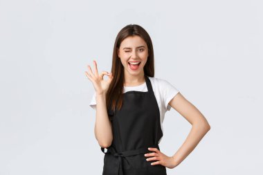 Market çalışanları, küçük işletmeler ve kahve dükkanları konsepti. Neşeli, mutlu, gülümseyen barmen tamam diyor, iyi bir hareket gösteriyor. Cafe çalışanı şehirdeki en iyi kahveyi garanti ediyor.