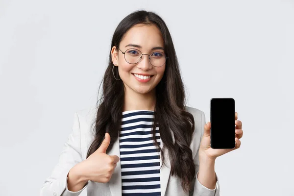 Företag, finans och sysselsättning, kvinnliga framgångsrika entreprenörer koncept. Närbild av eleganta moderna asiatiska affärskvinna införa mobil ansökan, visar tummen upp i godkännande — Stockfoto