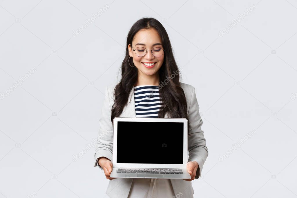 Business, finance and employment, female successful entrepreneurs concept. Enthusiastic businesswoman in suit and glasses showing presentation, demonstrate her project on laptop screen