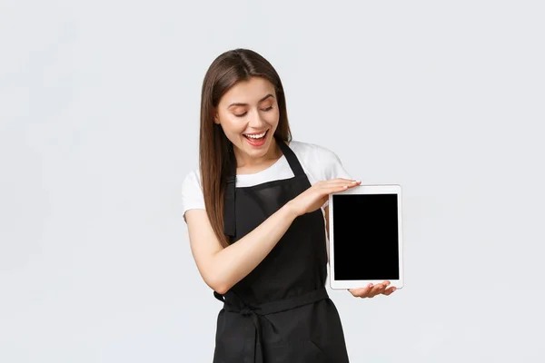 Empleados de tienda de comestibles, concepto de pequeñas empresas y cafeterías. Alegre amigable trabajadora cafetería mostrando la pantalla de tableta digital, mostrar aplicación de pedido en línea. Barista presenta nuevo menú — Foto de Stock