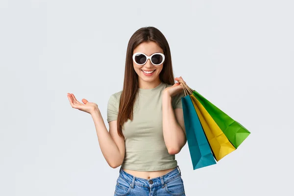 购物商场,生活方式,旅游和时尚观念.戴着太阳镜的时尚无忧无虑的女人，女游客背着购物袋买衣服，开心地笑着 — 图库照片