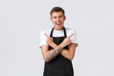 Küçük işletme sahipleri, kahve dükkanı ve personel konsepti. Heyecanlı, yakışıklı, gülümseyen barista, kafede garsonluk yapan ve mutlu görünen, iki harika yaz içkisi içen.