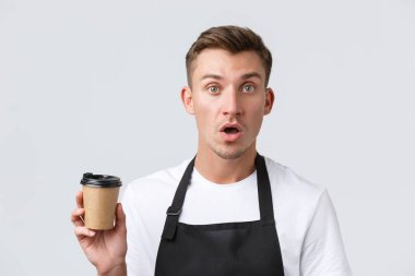 Kafe ve restoranlar, kafe sahipleri ve perakende konsepti. Ürkmüş ve kafası karışmış barista, siyah önlüklü garson elinde paket içecek, beyaz arka plan.