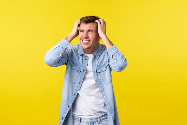 Mode de vie, émotions des gens et concept de loisirs d'été. Homme blond inquiet et anxieux saisir la tête et regarder désespéré, jeu, regarder l'échec, perdre et être en détresse, regarder à gauche — Photo