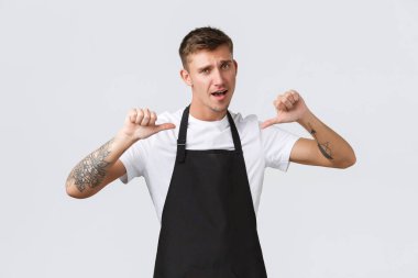 Küçük işletme sahipleri, kahve dükkanı ve personel konsepti. Siyah önlüklü market çalışanı mükemmel kalite ve hizmet garantisi veriyor. Kendini gösteriş budalası gösteriyor. Kafe kahvecisi kendini övüp duruyor.