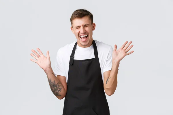 Small business owners, coffee shop and staff concept. Happy rejoicing silly barista, handsome guy working in cafe, jumping from happiness and shaking hands, shouting yes, restaurant finally open — Stock Photo, Image