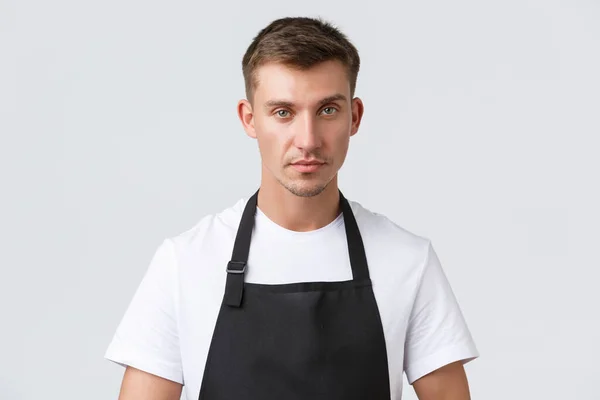 Cafe and restaurants, coffee shop owners and retail concept. Close-up of handsome waiter serving tables, taking client order, looking determined, listening to guest, standing white background — Stock Photo, Image