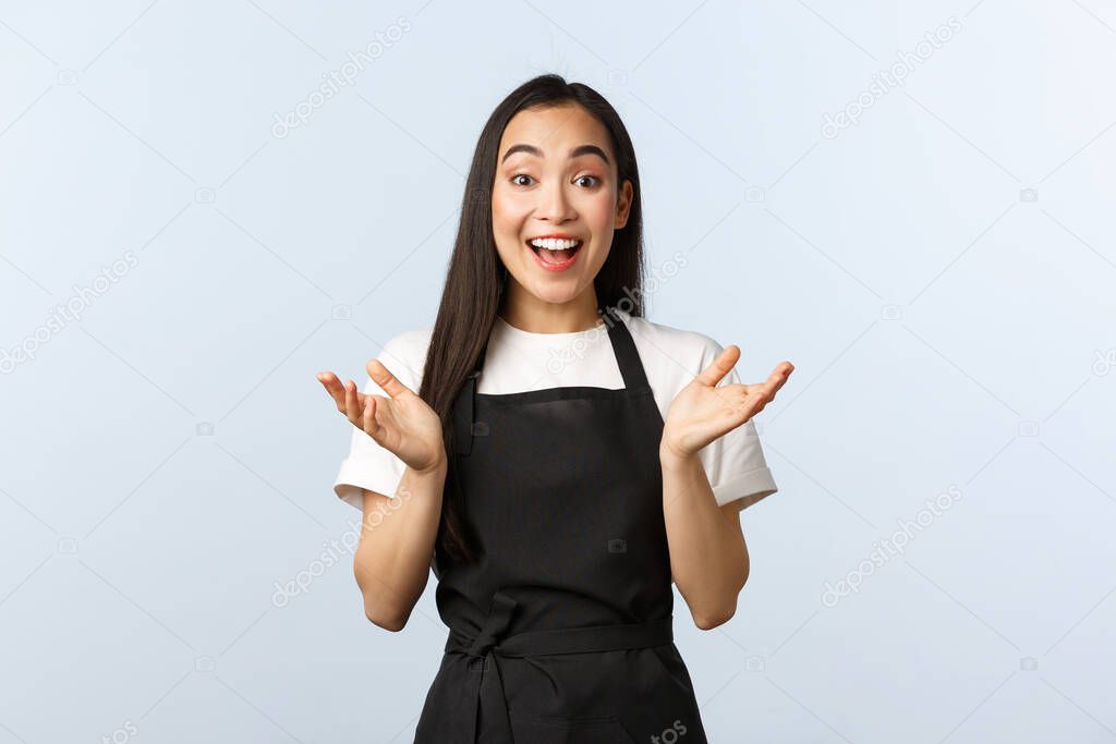 Coffee shop, small business and startup concept. Rejoicing attractive female barista clap hands amused, smiling hear good news, glad for you. Happy cheerful girl working in cafe, wear black apron