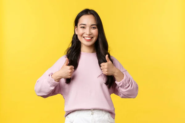 Lidé emoce, životní styl a módní koncept. vzrušený a potěšený pozitivní asijské žena ve stylovém oblečení, ukazující palce nahoru ve schválení, podporovat vás, doporučit promo, žluté pozadí — Stock fotografie