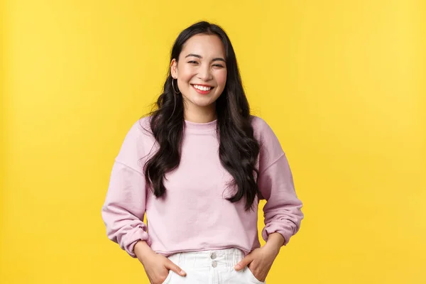 As pessoas emoções, estilo de vida e conceito de moda. Menina coreana alegre de boa aparência se divertindo, rindo e se sentindo feliz, de pé alegre sobre fundo amarelo — Fotografia de Stock