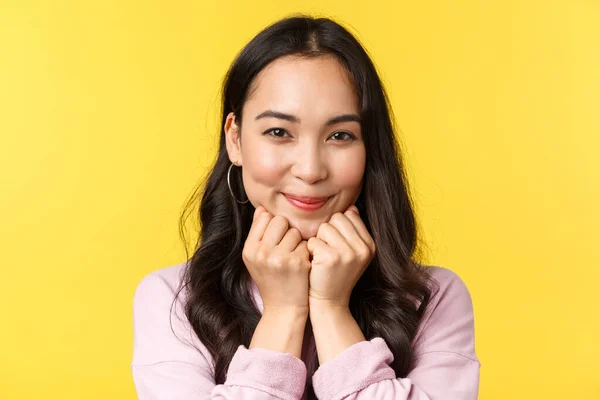 İnsanların duyguları, yaşam tarzı, eğlence ve güzellik konsepti. Sevimli Asyalı kadın kameraya gülümsüyor ve bakıyor sempati, şefkat, neşe ve sevgi hissediyor, reklam dükkânı, sarı arka plan — Stok fotoğraf