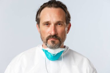 Covid-19, virüs, sağlık çalışanları ve aşı konsepti. Ciddi görünümlü doktorların yakın plan tıbbi solunum cihazları ve kameralar tespit edildi. Coronavirüs hastaları vardiyası bitti.