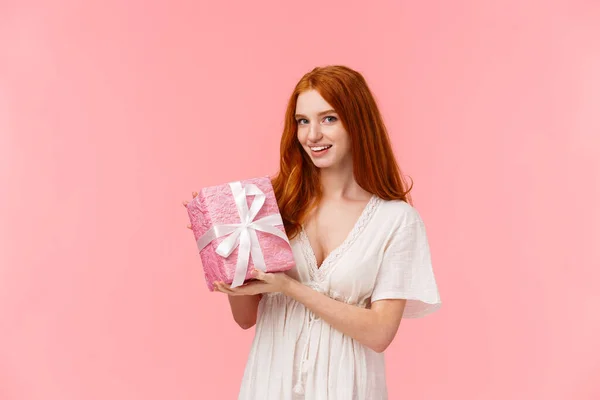 Retrato en la cintura novia pelirroja encantadora, romántica y femenina en vestido blanco, regalo lindo preparado. regalo envuelto en papel y cámara sonriente, felicitando amigo con cumpleaños — Foto de Stock