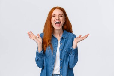 Lol çok komik. Neşeli ve kaygısız güzel kızıl kız el çırpıyor, alkışlar kapalı gözlerle kahkaha atıyor, eğleniyor, komik fıkra dinliyor, beyaz arka planda duruyor.