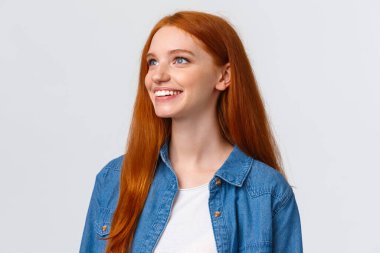 Yakın plan portre rüya gibi ve neşeli kızıl saçlı güzel bir manzara gören güzel bir şey düşün, gülümseyen ve bakan sol üst köşe zevkli, beyaz arka plan