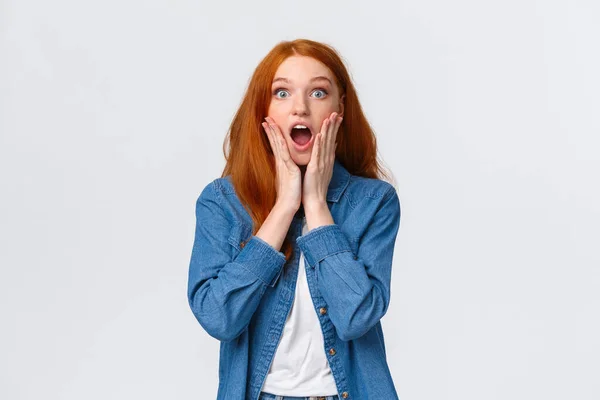 Oh my gosh, amazing. Surprised speechless redhead woman standing starled and shocked, touch face, drop jaw and stare camera fascinated, got job, won prize, standing white background — Stock Photo, Image