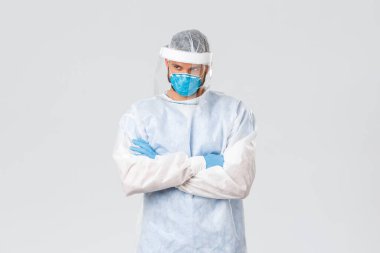 Covid-19 salgını, virüs salgını, klinik ve sağlık çalışanları konsepti. Kişisel koruyucu ekipmanlarda kendine güvenen doktor Coronavirus 'la savaşmayı ve hasta hastaları tedavi etmeyi belirledi.