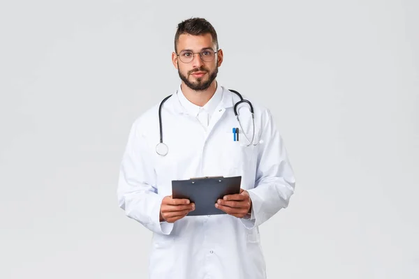 Travailleurs de santé, assurance médicale, laboratoire clinique et concept covid-19. Jeune médecin hispanique professionnel en manteau blanc avec stéthoscope et presse-papiers, à l'écoute des patients à l'hôpital — Photo