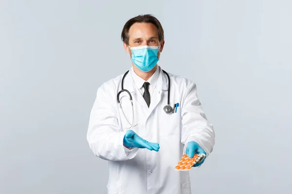 Covid-19: 바이러스 예방, 의료 종사자 및 예방 개념. 의료용 마스크를 쓰고 약물을 가리키는 장갑을 낀 친절 한의사는 이 인플루엔자 약을 사용 할 것을 권장 한다 — 스톡 사진