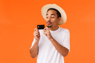 Adam parayı israf etmeyi seviyor, sevgililer günü için bilet almayı sevgililer günü hediyesi, tatil köyü, kredi kartını öperek nakit para biriktirmeyi, seyahat için para biriktirmeyi, turuncu arka plan