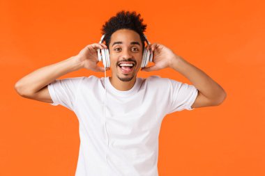 Mutlu ve yakışıklı Afro-Amerikan adam, kulaklıkla müzik dinle, sanatçının yeni single 'ının keyfini çıkar, kamera sorgusuna bak biri onu çağırırken, kalkış kulaklığı takıyor.