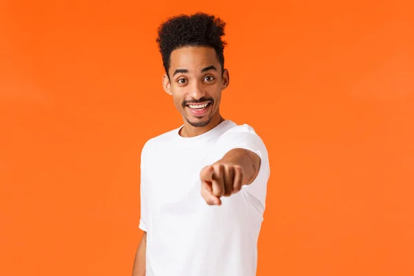 We need you, hired. Cheerful and assertive african-american guy making his final choice, decide, found excellent candidate, pointing camera inviting to work together, smiling, orange background — Stock Photo, Image