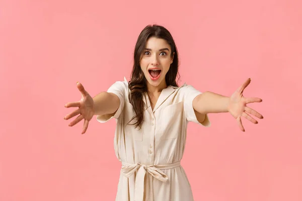 Vem para os meus braços. Garota branca bonita excitada esticando as mãos para a frente para segurar, tomar algo, alegremente sorrindo, abraçando amigo, cumprimentando namorada, indo às compras, fundo rosa — Fotografia de Stock