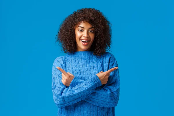 Carismática sonriente mujer afro-americana feliz con corte de pelo afro, señalando los dedos izquierda y derecha, indicando de lado con las manos cruzadas sobre el pecho, sonriendo, recomendar dos productos, publicidad — Foto de Stock