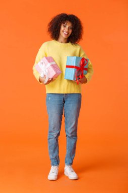 Tam boy dikey çekim. Çekici, neşeli, Afro-Amerikalı bir kadın. Bayramlara hazırlanıyor, ailesine hediyeler alıyor.