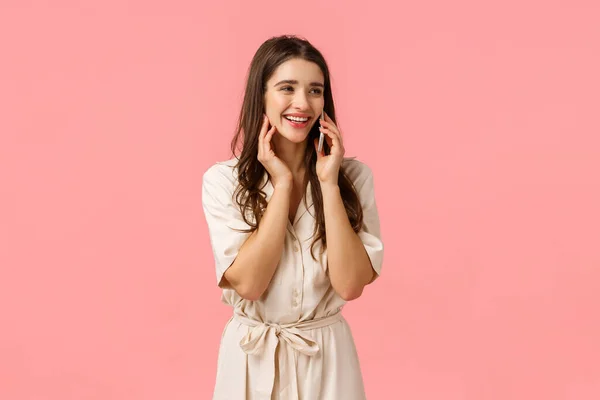 Alegre sedutor e despreocupado mulher feliz no vestido, rindo falando no telefone, chamando melhor amigo e discutir data romântica, segurando smartphone perto da orelha, olhar para o lado, fundo rosa — Fotografia de Stock