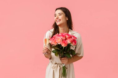 Zarafet, romantizm ve sevgililer günü konsepti. Kadın doğum gününü kutluyor, eğleniyor, eğleniyor, şampanya bardağı tutuyor, içiyor ve gülüyor, güzel çiçekler alıyor.