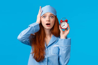 Endişeli ve endişeli tatlı, kasvetli, üzgün, üzgün, üzgün bir kız. Alarmı kurmayı unutmuş, işe geç kalmış, sabah rahatsız uyanmış, elinde çalar saatle uyanmış.