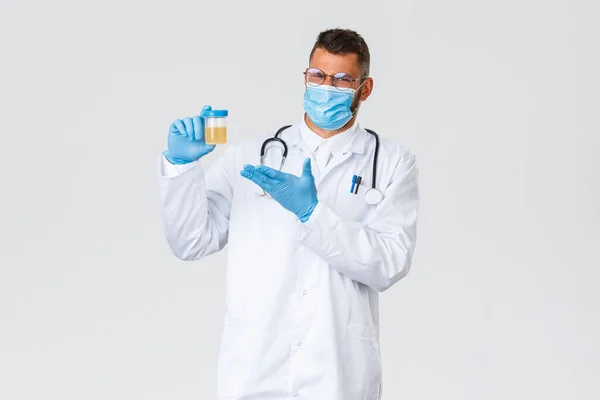 Covid-19, 의료 종사자, 전염병, 그리고 바이러스의 개념 방지. 의료용 마스크와 장갑을 끼고 있는 실망하고 당황 한 의사와 안 좋은 소변 검사를 보여 주는 장갑을 끼고 있는 의사는 불쾌 해 하고 있었다 — 스톡 사진