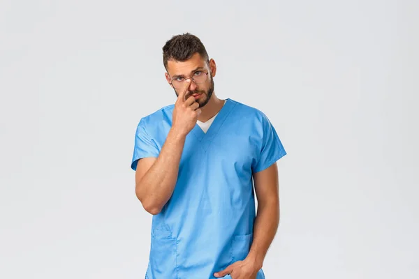 Health care workers, medicine, covid-19 and pandemic self-quarantine concept. Infirmière masculine séduisante, médecin en blouse bleue et lunettes, caméra déterminée — Photo