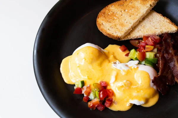 Uova Benedict - pane, becon e pomodoro, uova in camicia e deliziosa salsa olandese burrosa — Foto Stock