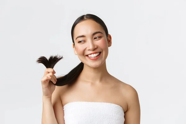 Kecantikan, produk rambut rontok, sampo dan konsep perawatan rambut. Wanita asia yang cantik dengan handuk mandi menunjukkan ujung rambut dan senyum puas, ujung yang sembuh dan terlihat puas — Stok Foto