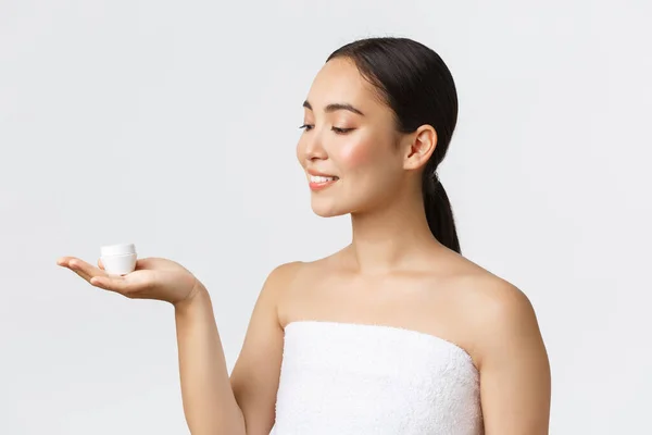 Kecantikan, perawatan pribadi, salon spa dan konsep perawatan kulit. Close-up of beautiful asian woman in bath towns introduction facial cream, moisturizing or hydrating treatment for face, skin ourishing — Stok Foto