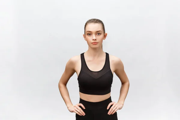 Attractive young adult in sportswear posing on white background. Sexy and sensual brunette woman with perfect body posing in studio isolated over white background with copyspace — Stock Photo, Image