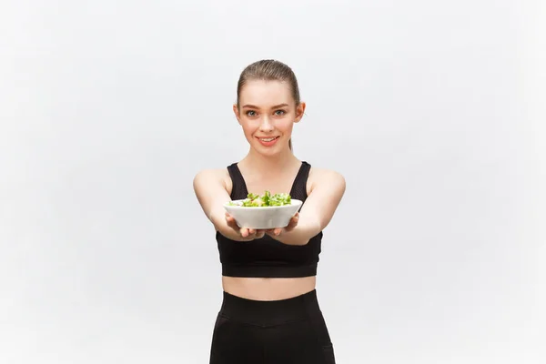 Saludable mujer fitness comer ensalada y de pie, aislado sobre fondo blanco . —  Fotos de Stock