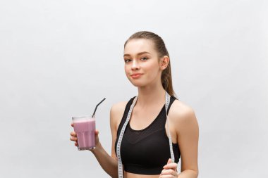 Sağlıklı diyeti olan genç ve mutlu bir kadın spor ve spor olsun diye içiyor..