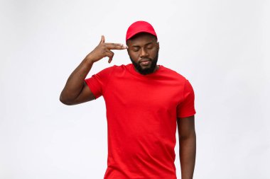 Teslimat Konsepti - Ciddi Afro-Amerikan teslimatçının portresi aptalca agresif bir ifade sergiliyor ve mutsuz. Grey Stüdyo Arkaplanı 'nda izole edilmiş. Boşluğu Kopyala.