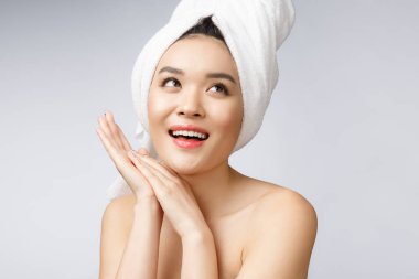 Beyaz dişleriyle gülümseyen güzel Asyalı genç kadın, çok mutlu ve sağlıklı tenli, beyaz arka planda soyutlanmış.